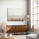 Abstract gradient artwork in muted neutrals above mid-century credenza in minimalist interior.