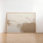 Neutral abstract horizon painting with beige tones in minimalist wooden frame against white wall.