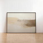 Minimalist abstract landscape print in earthy neutral tones, leaning against white wall.