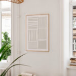 Minimalist geometric wall art with natural light and indoor plant in contemporary home setting.