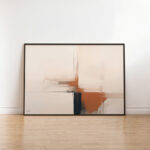 Abstract art in terracotta and navy tones against white wall on wooden floor.