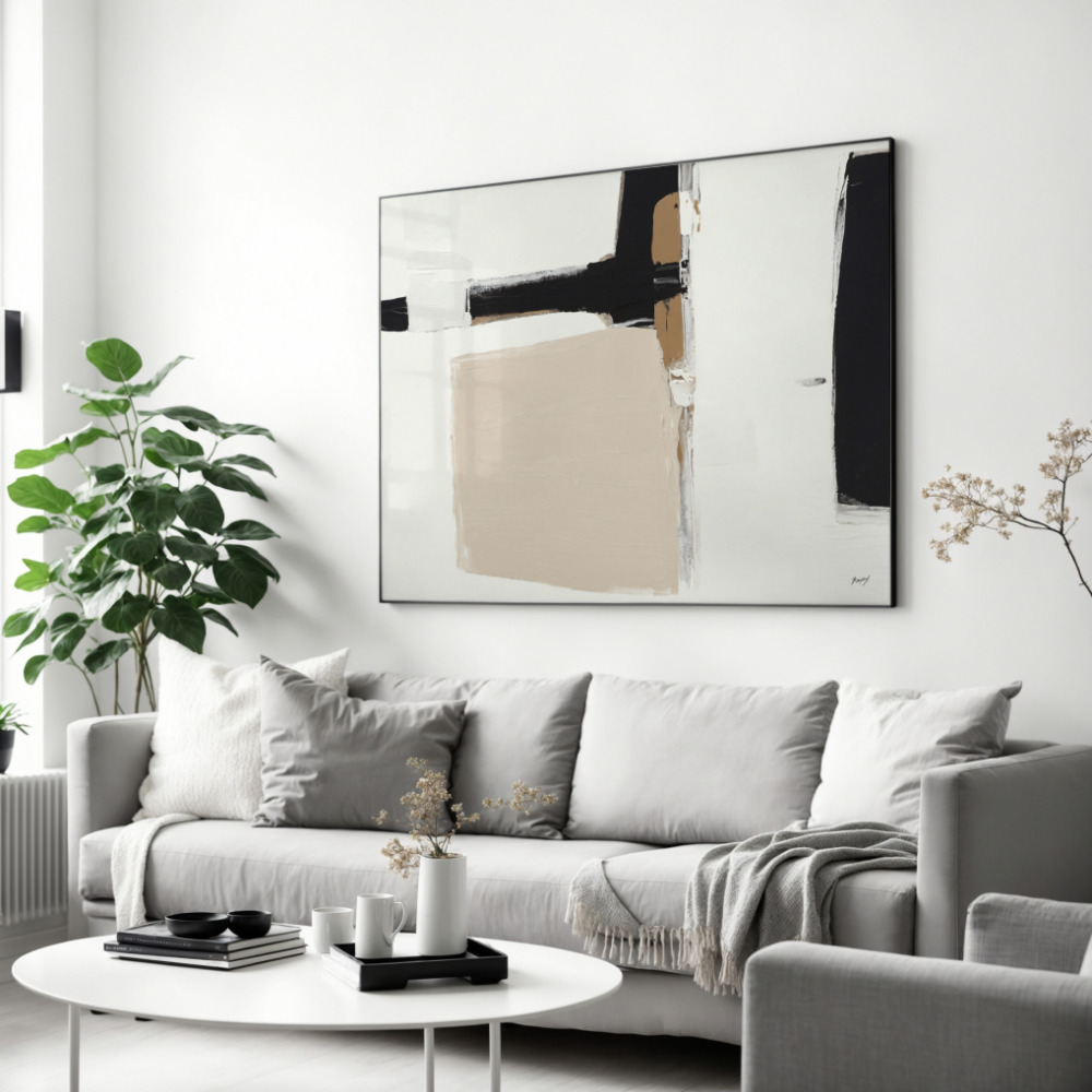 Large abstract black and beige painting over gray sofa with white coffee table.