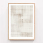 Minimalist framed artwork with vertical lines in neutral tones on white wall.