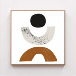 Minimalist geometric wall art with black circle, speckled crescent, and terracotta arch.