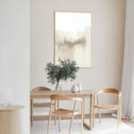 Abstract landscape artwork in neutral tones above minimalist wooden dining table with vase.