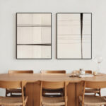 Minimalist dining area with wooden table, chairs and abstract geometric artwork in neutral tones.