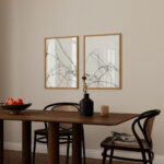 Minimalist dining area with wooden table, bentwood chairs and abstract line art frames.