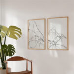 Minimalist black line art prints paired with monstera plant in contemporary interior design.