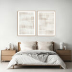 Minimalist bedroom with twin abstract line art above wooden framed bed.