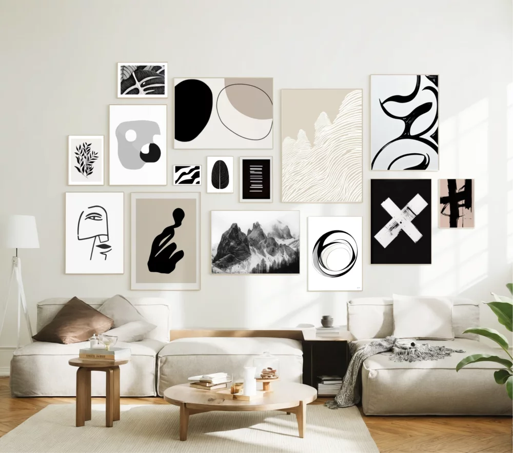 Modern abstract gallery wall with black and white prints above minimalist living room furniture.