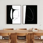 Minimalist black and white abstract art above modern wooden dining table set.