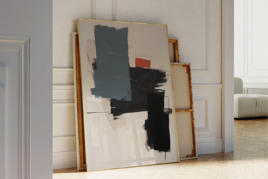 Abstract paintings leaning against white wall in elegant interior space.