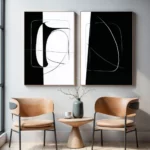 Abstract black and white diptych art above wooden table with chairs.