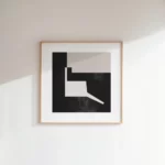 Minimalist black and white geometric abstract art in light wooden frame.