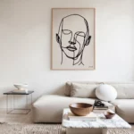 Minimalist living room featuring line art portrait above cream sofa and marble coffee table.