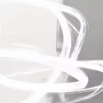 Abstract white brushstrokes flowing across light gray background creating ethereal movement.