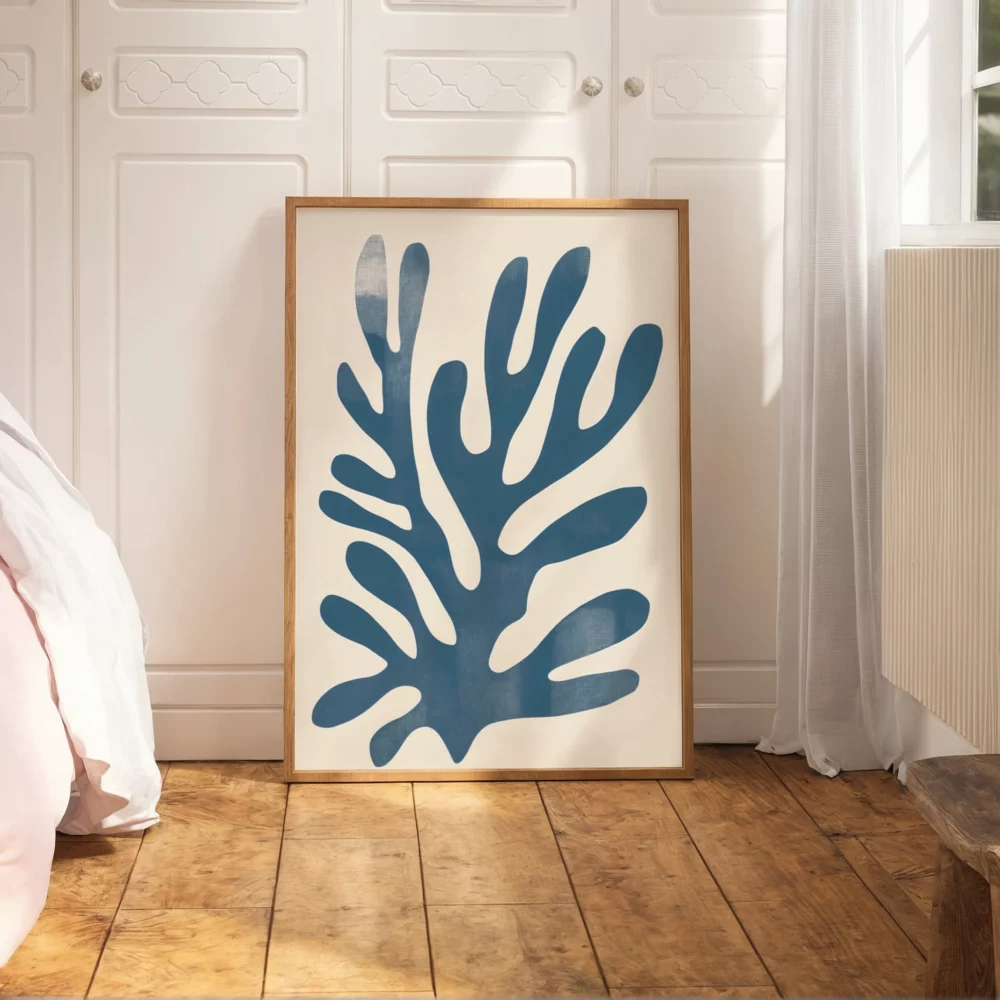 Blue coral wall art leaning against white cabinetry in modern bedroom.