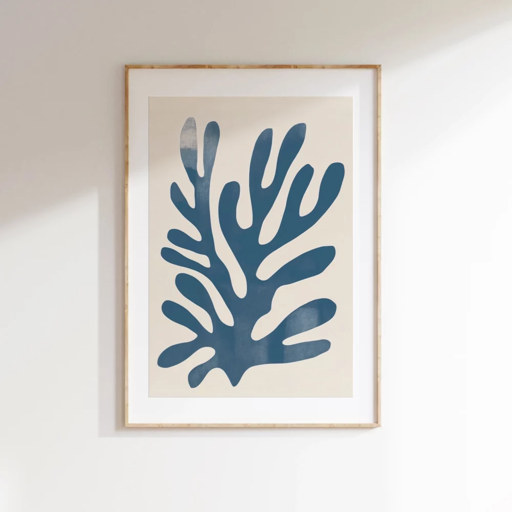 Framed minimalist blue coral print in light wood frame on white wall.