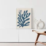 Minimalist blue Matisse-inspired artwork with white vase on modern cabinet.