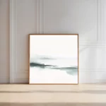Minimalist abstract horizon artwork leaning against white paneled wall in modern interior.