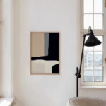 Minimalist bathroom with black abstract art and modern task lamp near window.
