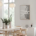 Minimalist dining area with wooden table, pendant light and natural sunlight.