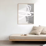 Minimalist interior with abstract art above wooden daybed in neutral colors.