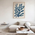 Minimalist living room with modern blue coral artwork above cream sectional sofa.
