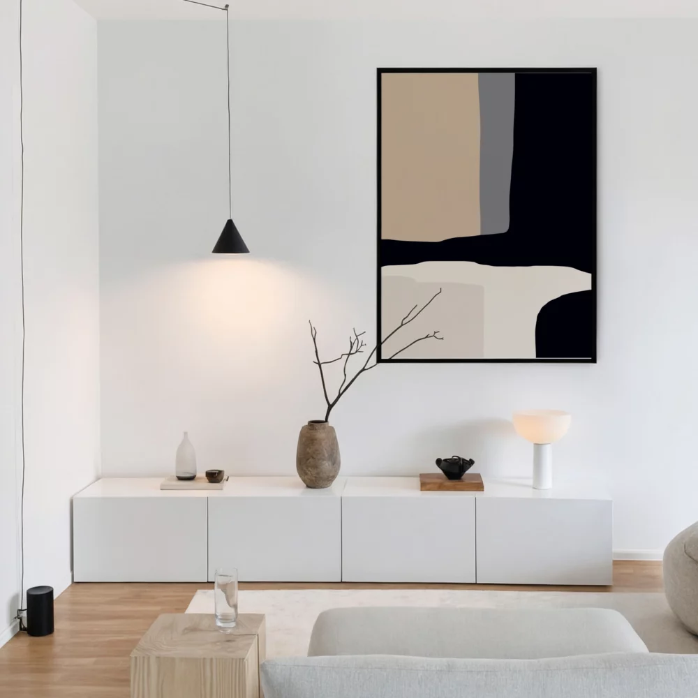 Minimalist white living room with abstract art and sleek storage cabinet.