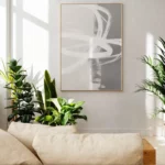 Minimalist living room with abstract wall art and green plants.