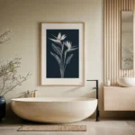 Framed white line art print of Bird of Paradise flowers on a dark navy background, decorating a light wall above a modern freestanding bathtub in a serene bathroom with wooden vanity.