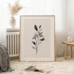 Large framed black and white botanical branch art print, leaning against a white wall on a textured rug, creating a cozy and minimalist atmosphere.