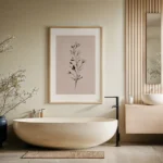Framed black and white botanical sprig art print on a blush background, displayed on a wall above a modern freestanding beige bathtub in a serene minimalist bathroom.