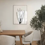 Contemporary black and white cactus line art print, displayed in a neutral-toned dining room with a wooden table, chairs, and an olive tree.