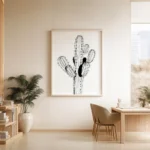 Large framed black and white line art print of a cactus, decorating a light-colored wall in a minimalist dining area with a wooden table, chairs, and a potted plant.