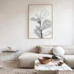 Minimalist framed line art print of a fiddle leaf fig, displayed above a light-colored sectional sofa in a bright, neutral living room.