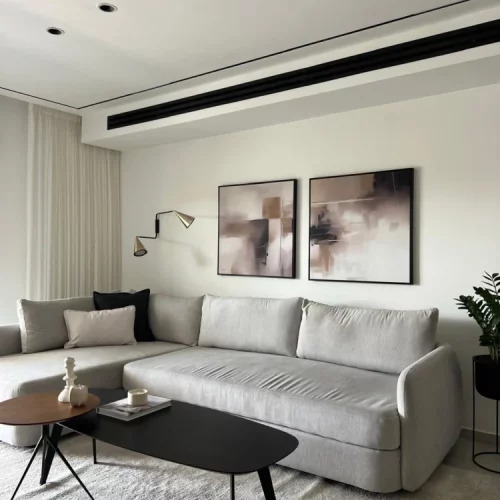 Minimalist gray living room with abstract art and modern furniture.